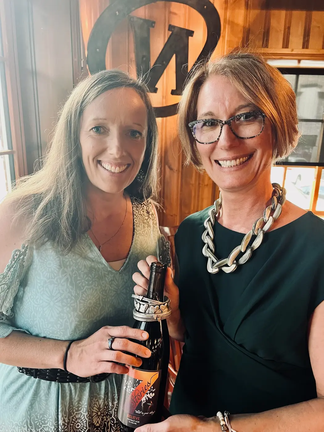 7 Stories founders Andi and Jesi together with a bottle of wine
